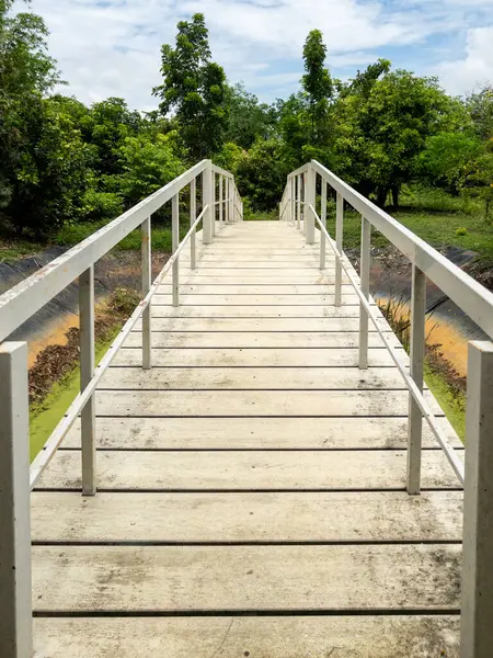 The white wooden bridge above the empty reservoir in the garden of the local restaurant, front view with the copy space.