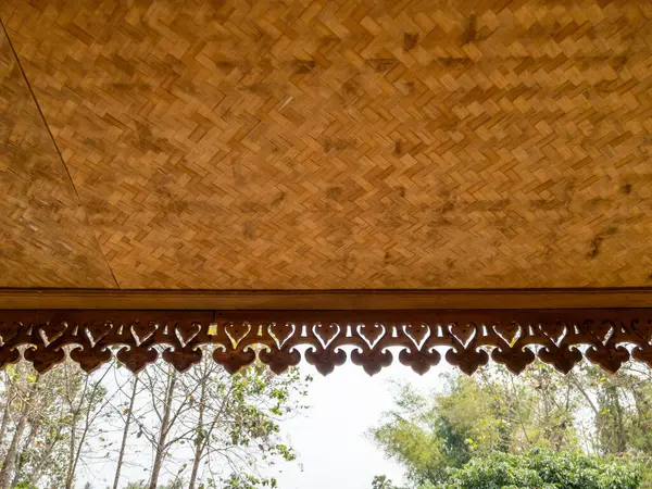 stock image The wooden eaves with the flower stencil are decorated on the edge of the old house, front view with the copy space.