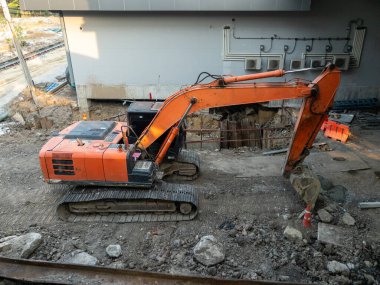 Şehrin demiryolu istasyonu inşaatı için kullanılan büyük turuncu kazıcı, fotokopi alanı için önden görüş..