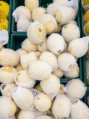 Taze armudun beyaz tek kullanımlık tamponunda yakın plan, süpermarkette bir meyve tezgahında, fotokopi alanının olduğu ön görüş.