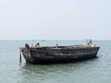 Terk edilmiş ahşap bir gemi liman yakınlarında karaya oturmuş, kopyalanmış bir fırtına yüzünden kırılmış, fotokopi alanının ön görüntüsü..