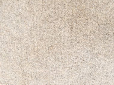 Yumuşak kahverengi bir halının detaylı bir yakın çekimi, narin liflerini ve karmaşık dokularını sergiliyor. Tarafsız tonlar ve pelüş maddeler sıcak ve samimi bir estetik oluşturuyor. arkaplan için ön görünüm.