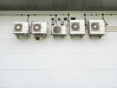 Endüstriyel soğutma ve elektrik sistemlerinin yer aldığı bir trenin güç kontrol binasının duvarındaki klima kompresörleri. Teknoloji, mühendislik ve altyapı temaları için harika.