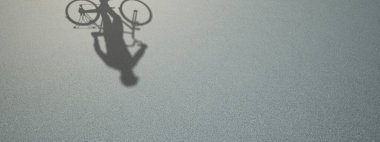 Görüntü olarak insan gölgesi olan zemin dokusu yüzeyinin kavramsal veya kavramsal arkaplanı. Bisiklet rekreasyonu için 3 boyutlu bir metafor, eğlence amaçlı bisiklet tasarımı için sağlıklı bir yaşam tarzı