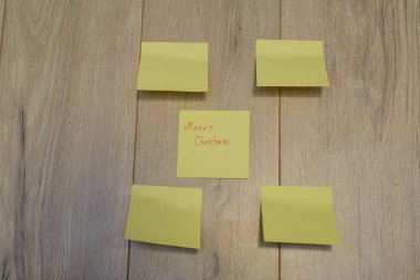 Ahşap bir arka planda yapışkan notlara yazılmış Mutlu Noeller.
