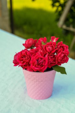 Kırmızı çiçeklerden yapılmış küçük pembe bir buket.