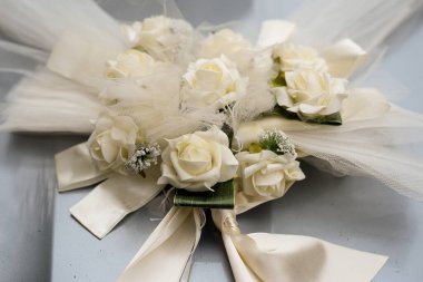 Dekoratif kurdeleli beyaz çiçekler bir arabanın kaputunda düğün süsü olarak.