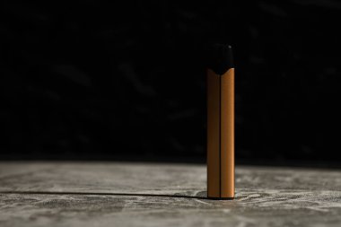 Siyah arka planda binlerce esinti ve gri yansıtıcı yüzeyi olan elektronik sigaralar.