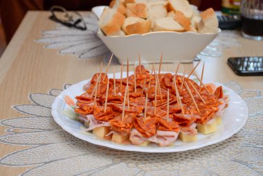 Peynirli, jambonlu ve kulen tabakta servis edilen küçük lokmalar. Nefis kanepeler.