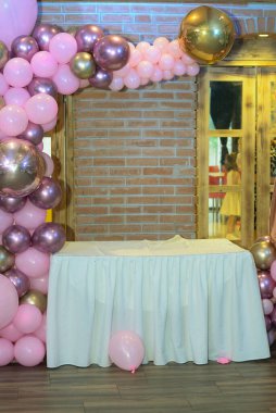 23 Haziran 2019 - Belgrad, Sırbistan. Masanın etrafına bir numaralı ve daha küçük pembe, altın ve mor balonlar şeklinde balonlardan yapılmış bir doğum günü pastası asılacak.