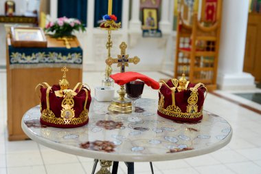 Ortodoks Hıristiyan Kilisesi 'nin bir parçası olarak ortada mum bulunan bir masada iki taç.