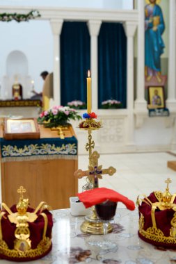 Ortodoks Hıristiyan Kilisesi 'nin bir parçası olarak ortada mum bulunan bir masada iki taç.