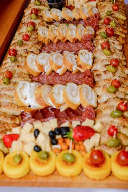 Lezzetli lokmalar ve aperatifler, hamur, et ve pişirilmiş etler yenmeye hazır. Etten mezelere, meyve süslemeleriyle