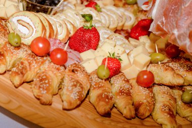 Lezzetli lokmalar ve aperatifler, hamur, et ve pişirilmiş etler yenmeye hazır. Etten mezelere, meyve süslemeleriyle
