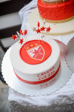 24 Eylül 2022 - Belgrad, Sırbistan. Kırmızı ve beyaz doğum günü pastası, üzerinde Kızıl Yıldız futbol kulübü amblemi ve kadın ismi Nancy 'nin yanı sıra 18 numara şeklinde bir mum var.