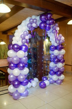 Mavi ve beyaz balonlardan yapılmış bir fotoğraf arkaplanı ve küçük aydınlatma armatürlerinden yapılmış bir perde.