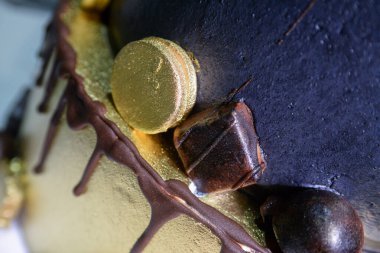 On sekizinci yaş günümü kutlamak için yapılmış üç katlı siyah çikolatalı pasta. Üstteki yazıda doğum günün kutlu olsun yazıyor. Her şey taşmış gibi görünüyor ve çeşitli şekillerde çikolatalarla süslenmiş..