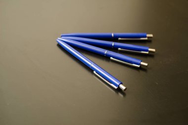 Siyah üzerine mavi renkli tükenmez kalemler. koyu arkaplan