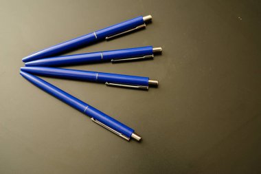 Siyah üzerine mavi renkli tükenmez kalemler. koyu arkaplan