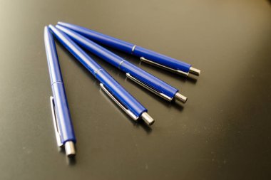 Siyah üzerine mavi renkli tükenmez kalemler. koyu arkaplan