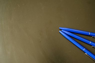 Siyah üzerine mavi renkli tükenmez kalemler. koyu arkaplan