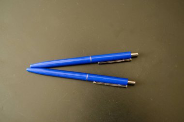 Siyah üzerine mavi renkli tükenmez kalemler. koyu arkaplan