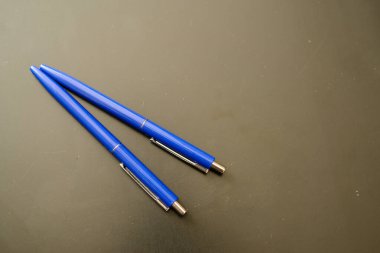 Siyah üzerine mavi renkli tükenmez kalemler. koyu arkaplan