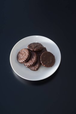 İki tarafı da çikolatalı bisküviler beyaz bir tabakta.