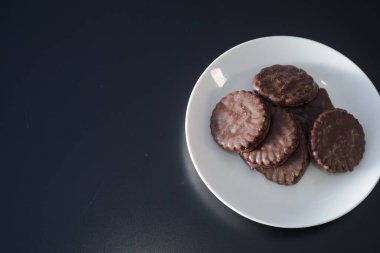 İki tarafı da çikolatalı bisküviler beyaz bir tabakta.