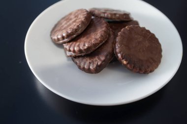 İki tarafı da çikolatalı bisküviler beyaz bir tabakta.