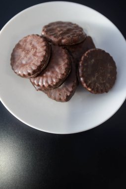 İki tarafı da çikolatalı bisküviler beyaz bir tabakta.