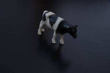 Siyah-beyaz evcil bir ineğin minyatür figürü karşı konulmaz bir şekilde köyü ve çocukluğu ve taze ev sütü tadını hatırlatıyor.