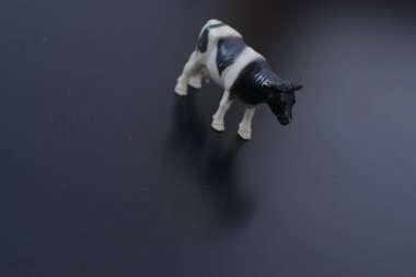 Siyah-beyaz evcil bir ineğin minyatür figürü karşı konulmaz bir şekilde köyü ve çocukluğu ve taze ev sütü tadını hatırlatıyor.