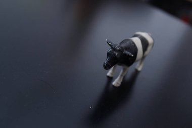 Siyah-beyaz evcil bir ineğin minyatür figürü karşı konulmaz bir şekilde köyü ve çocukluğu ve taze ev sütü tadını hatırlatıyor.