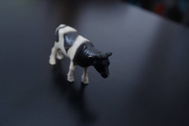 Siyah-beyaz evcil bir ineğin minyatür figürü karşı konulmaz bir şekilde köyü ve çocukluğu ve taze ev sütü tadını hatırlatıyor.