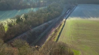 Train Carrying Commuters Speeding Through the Countryside Aerial View