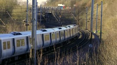 UK Commuter Train Travelling along the Railway Infrastructure