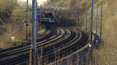 UK Commuter Train Travelling along the Railway Infrastructure