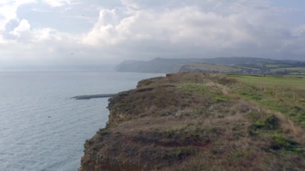 背の高い砂岩の崖がある西湾のビーチ次にイギリスの海 — ストック動画