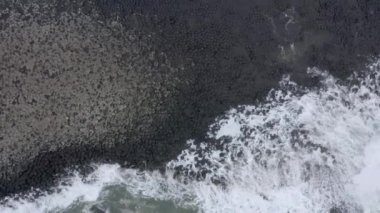 Dev Geçit 'te okyanus dalgaları altıgen bazalt kaya oluşumuna çarpıyor.
