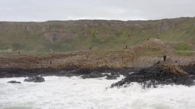 Dev Geçit 'te okyanus dalgaları altıgen bazalt kaya oluşumuna çarpıyor.
