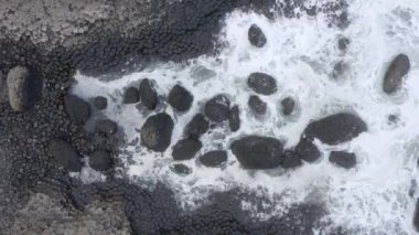 Dev Geçit 'te okyanus dalgaları altıgen bazalt kaya oluşumuna çarpıyor.