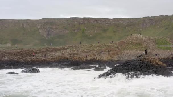 巨人のコーズウェイで六角形の玄武岩の形成に衝突する海の波 — ストック動画