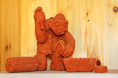 Clay figurine works by hand in a shop