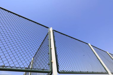 Mavi gökyüzü arkaplanındaki metal koruyucu ağ