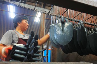 Luannan County, Çin - 22 Ağustos 2017: İşçiler Çin 'in Hebei Eyaleti' ndeki Luannan County 'deki çelik kürek üretim hattıyla meşguller