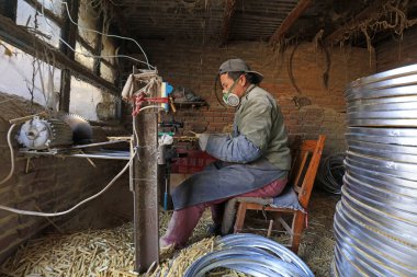 Luannan County - December 21, 2017: workers processing cover curtains in a handmade workshop, Luannan County, Hebei Province, China. This is the most important traditional handicraft industry in the local area