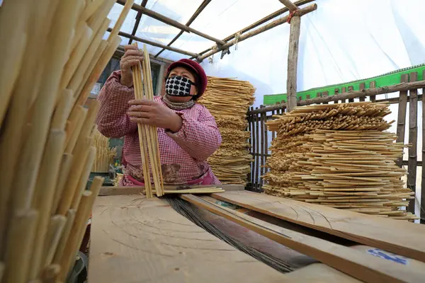 Luannan County - December 21, 2017: workers processing cover curtains in a handmade workshop, Luannan County, Hebei Province, China. This is the most important traditional handicraft industry in the local area