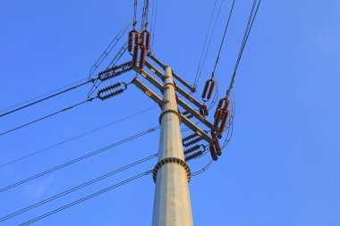 Mavi gökyüzü arka planında elektrikli çelik direkler