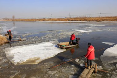 Luannan County - January 26, 2018: farmers use small boats to drive ice in the wild, Luannan, Hebei, Chin